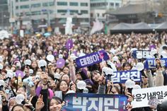 This contain a large group of 
K-pop fans
holding up signs