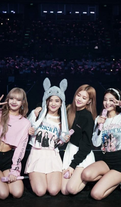 This contain BLACKPINK are posing together in front of an audience