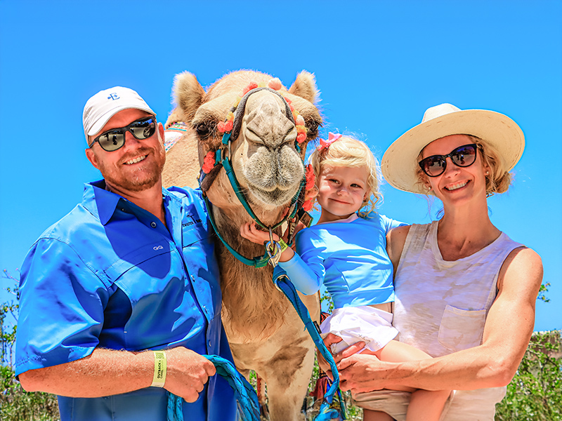 Family posing with a camel