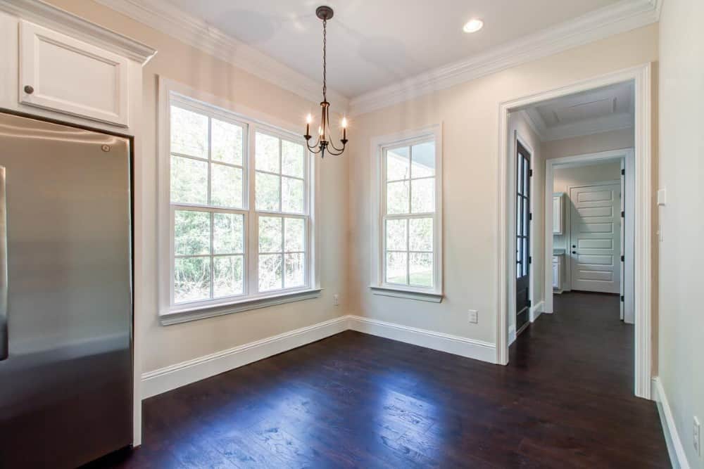 Dining area with white framed windows and a small chandelier hanging from the regular white ceiling.