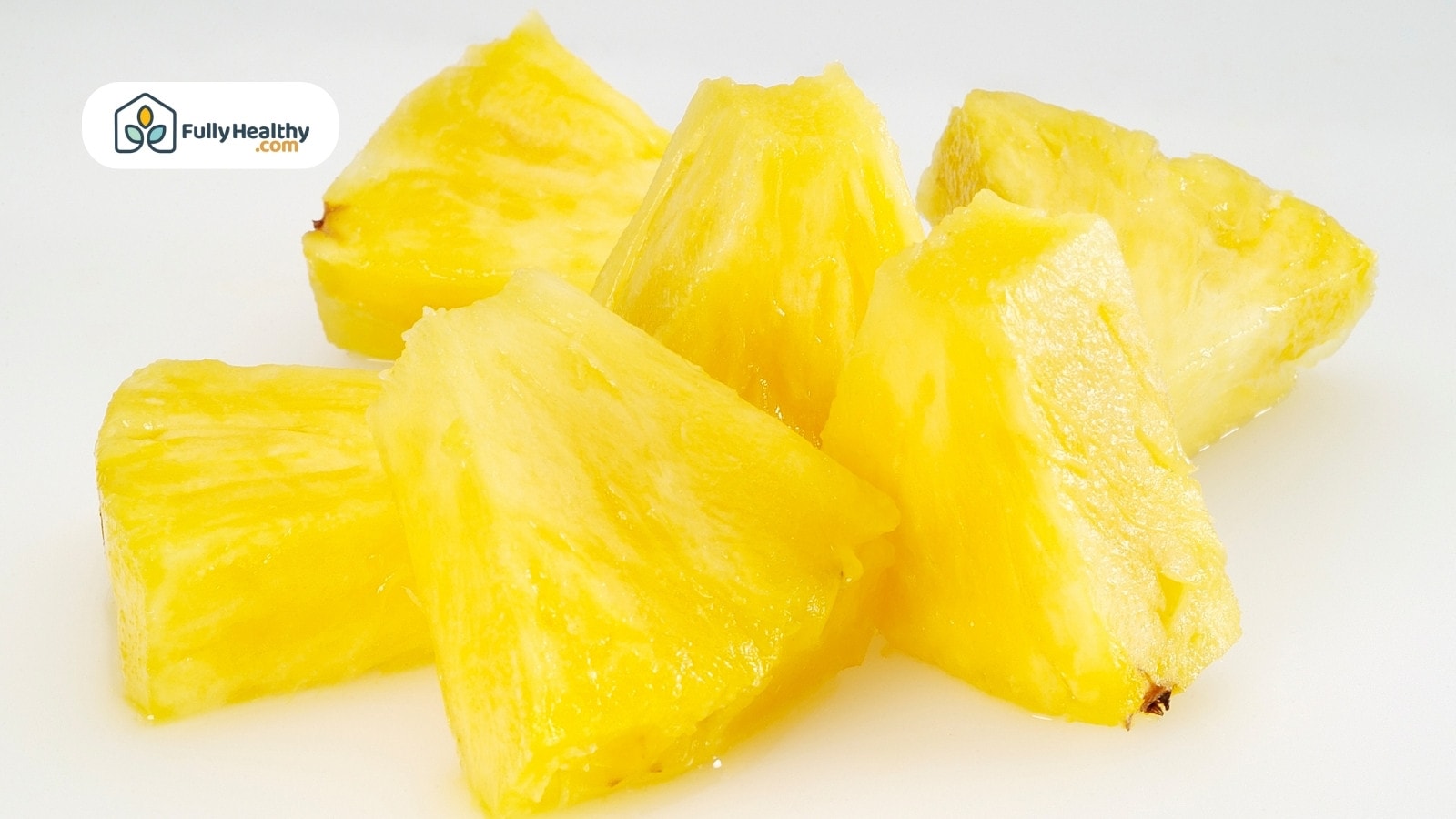 Juicy pineapple chunks on white background arranged in a small pile