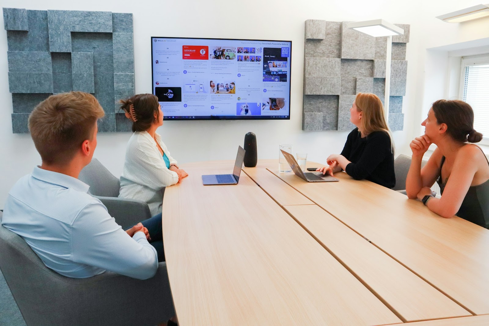 Team members in a meeting room, attentively looking at a presentation on a screen, working to improve team communication.