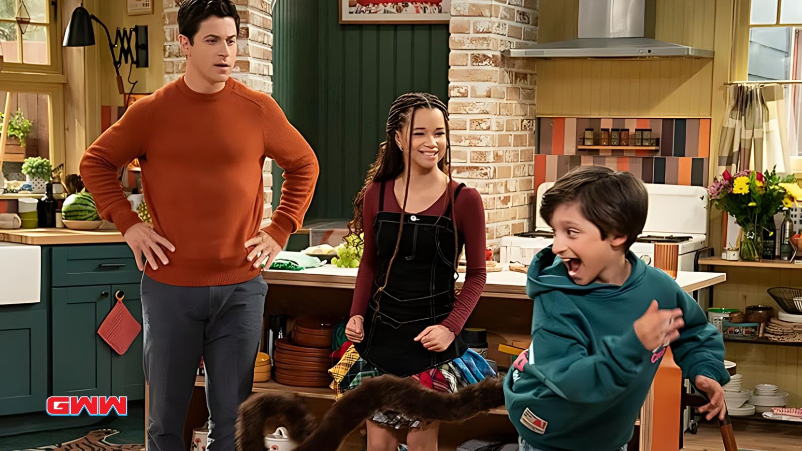 David Henrie with Janice Leann Brown and young actor in a kitchen scene from Wizards Beyond Waverly Place