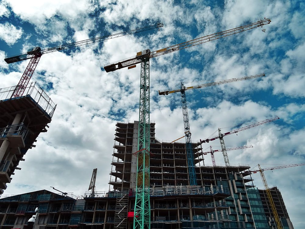 Skyscraper construction site with cranes, highlighting risk management in construction projects.