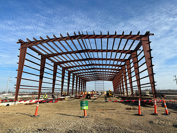 Steel frame of a pre-engineered dairy barn under construction, emphasizing the efficiency of steel structures in farming.