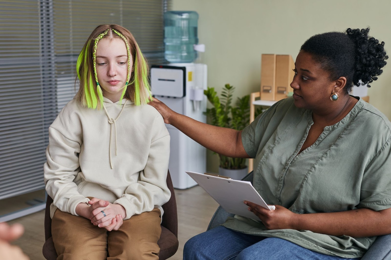 A female teen attends a psychological session with a female psychologist. 