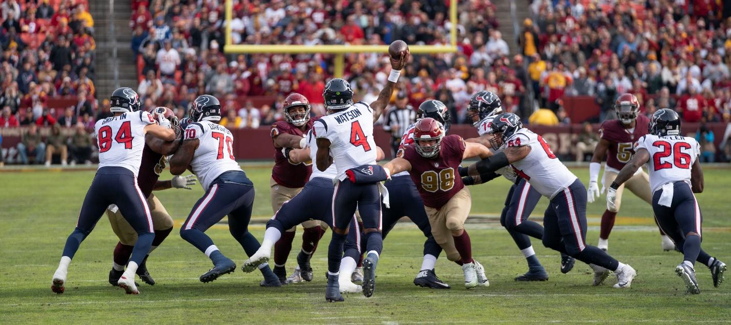 A group of football players on a field

Description automatically generated