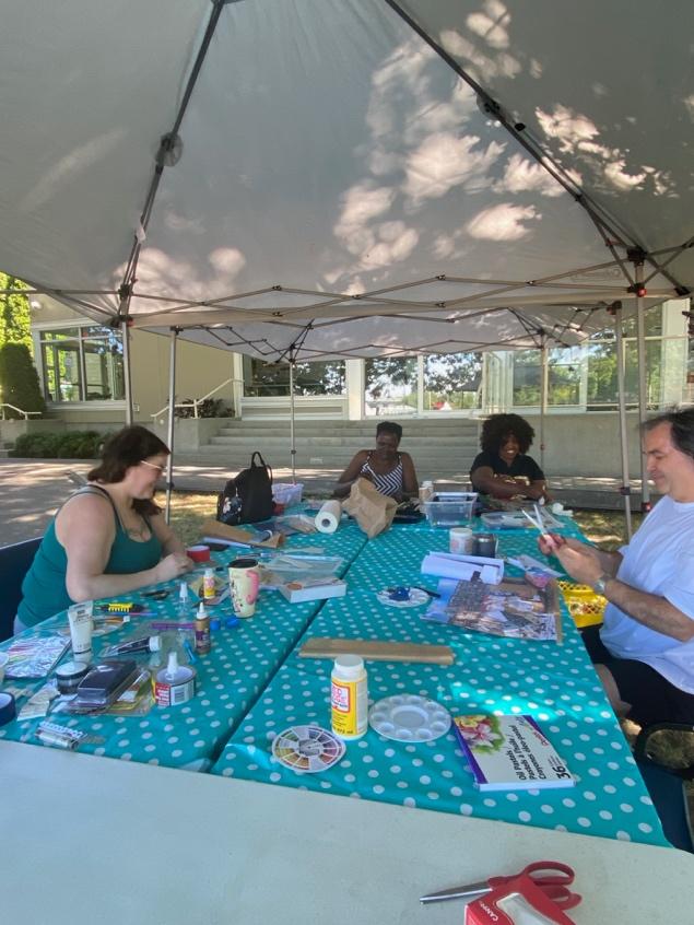 A group of people sitting at a table under a canopy

Description automatically generated