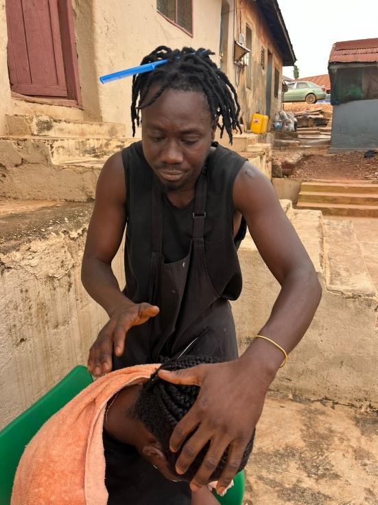 Finished braiding a client's hair in front of his house