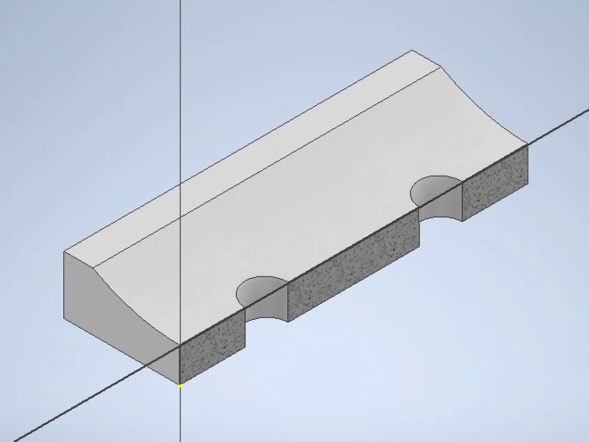 Sketch of a polygon with two semicircle cutouts on the front, and a horizontal line running along one front axis and a vertical line running along the left axis. The shape is gray, though the front is darker and speckled.