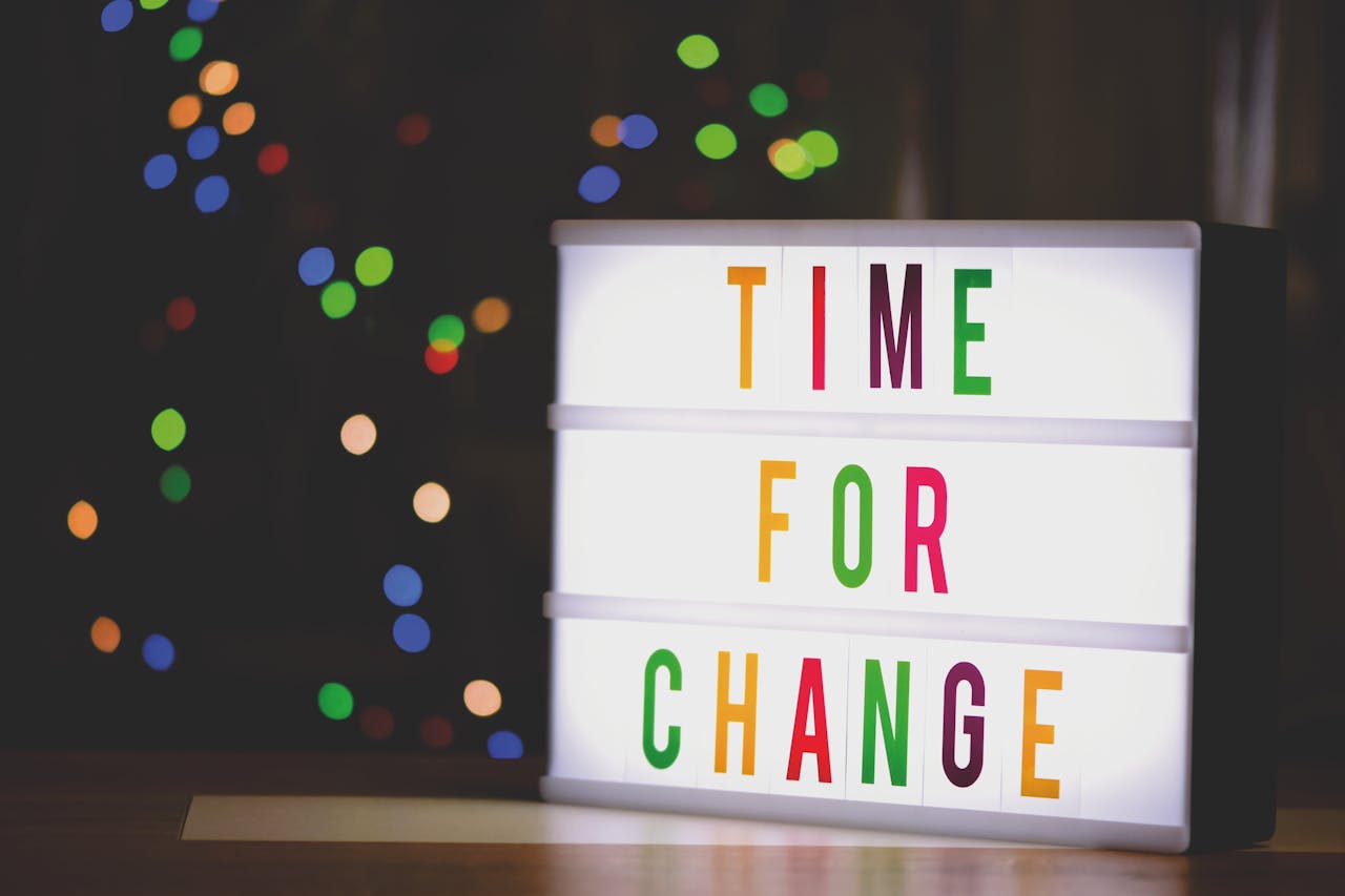 A signage with the words "Time for Change" with a colourful lighted background 