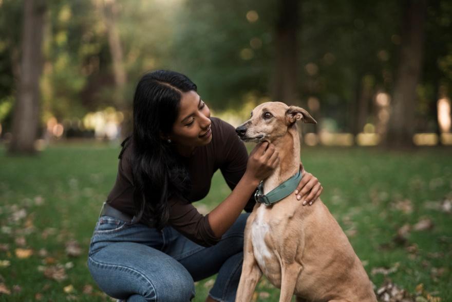 A woman talking to her dog in the park