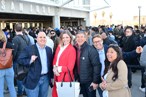 A group of people standing outside a building

Description automatically generated