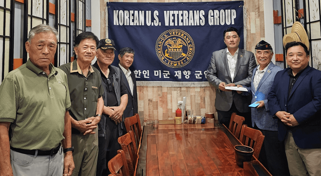 A group of men standing in front of a table

Description automatically generated