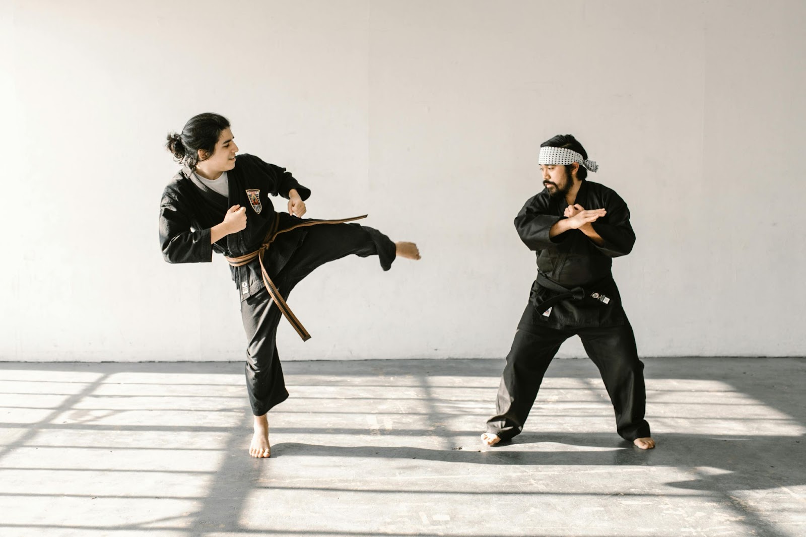 Two martial arts students practicing kicks