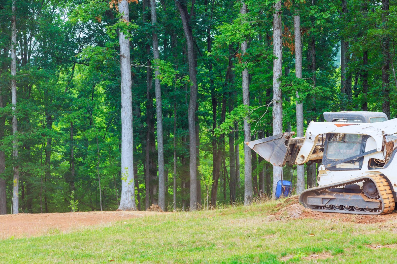 Bulldozer moving soil to grade land for landscaping preparation.