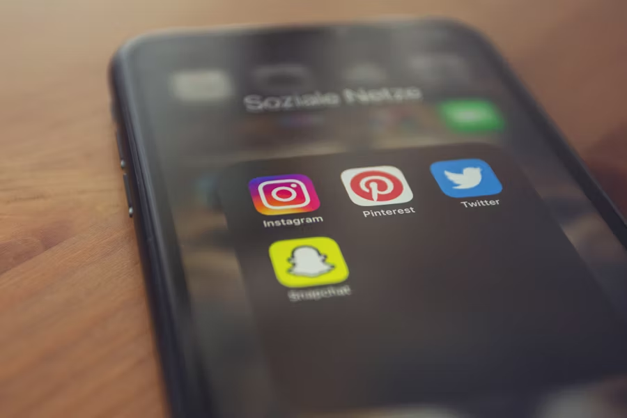 Smartphone screen showing various social media apps including Pinterest, highlighting its place in the digital ecosystem