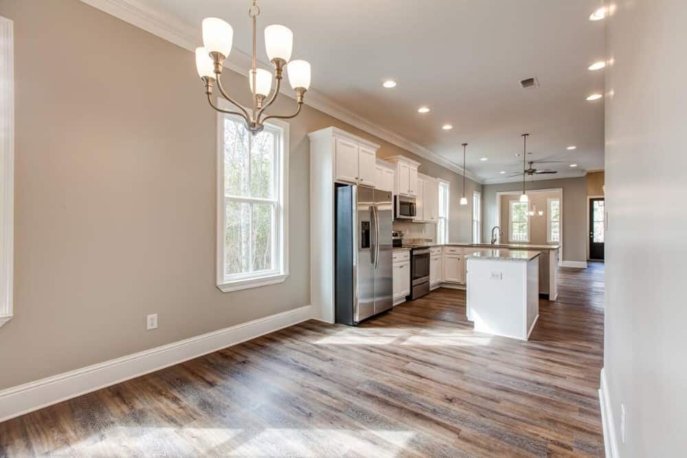 Across the kitchen is the dining space well-lit by a chrome chandelier.