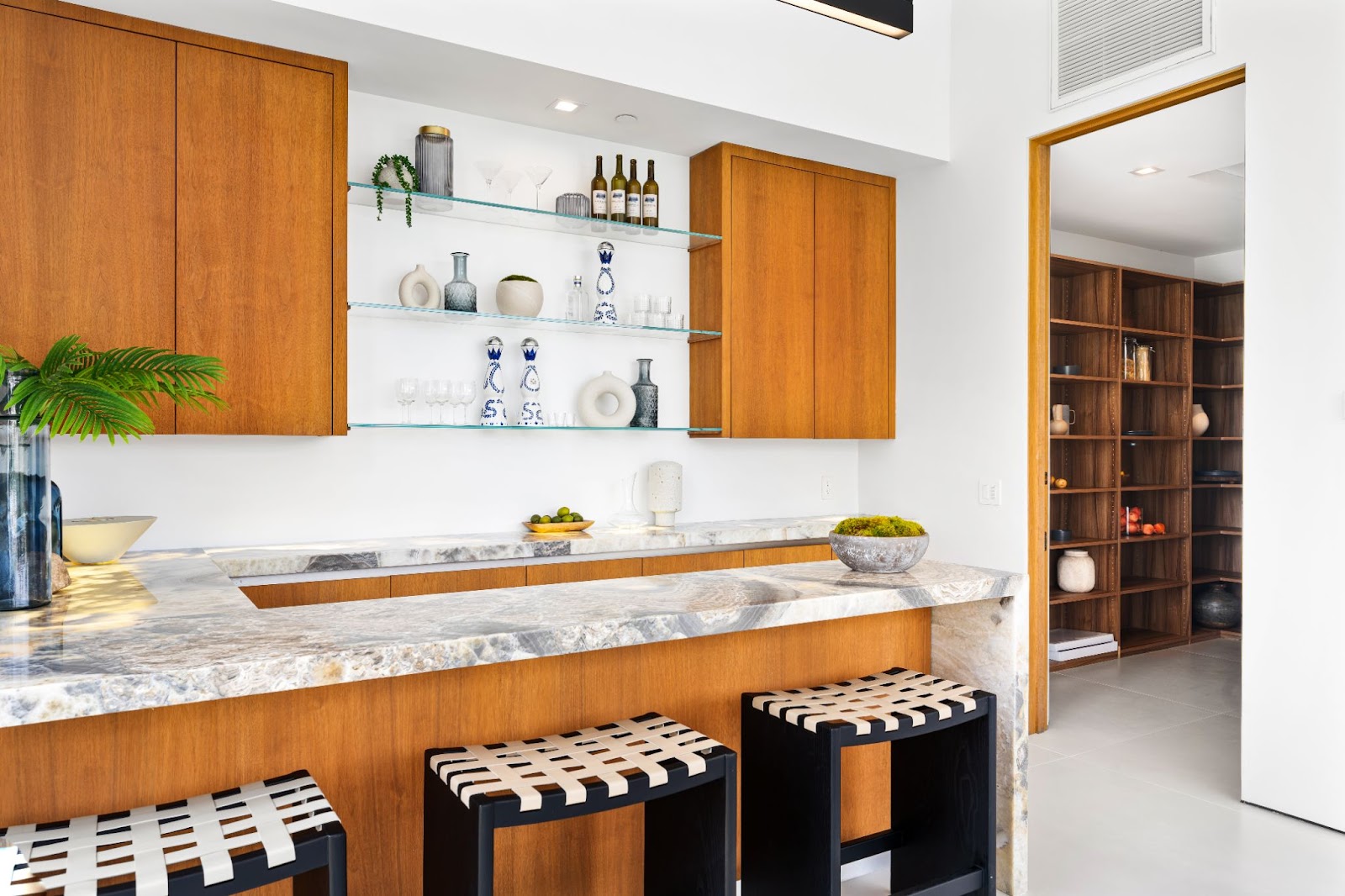  In-home bar with shelving and stools. 