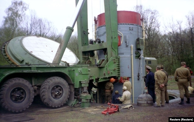 At a military base near Khmelnytskyi, workers remove the warhead of a Soviet-era SS-19 nuclear missile from a mine, preparing it for shipment to Russia, handing over the last 40 nuclear warheads to Russia. April 1995