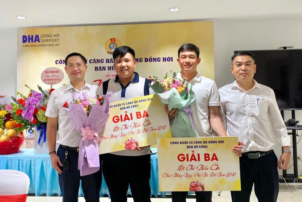 A group of men holding flowers and a signDescription automatically generated