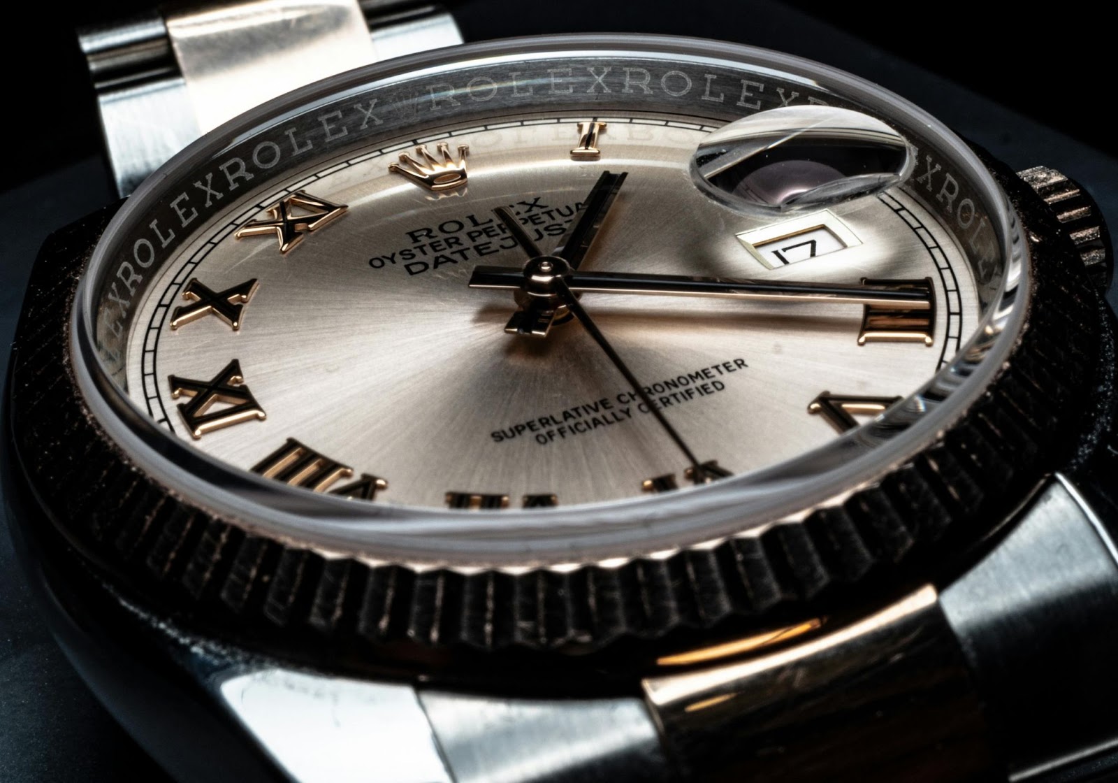 Close-up of a Rolex watch face, showing intricate details and date.