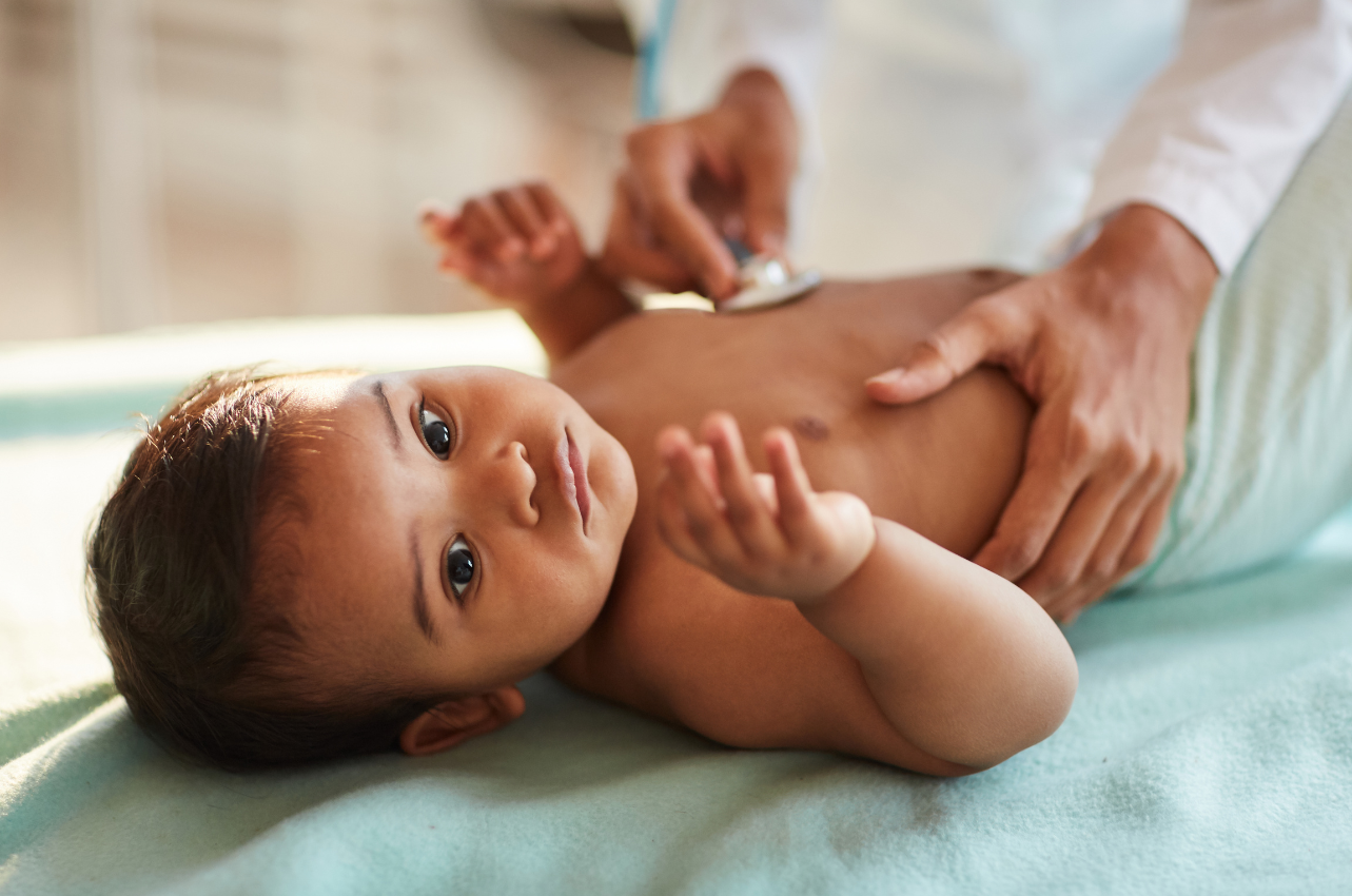 Baby lying on a doctor's bed / Healthier Baby Today