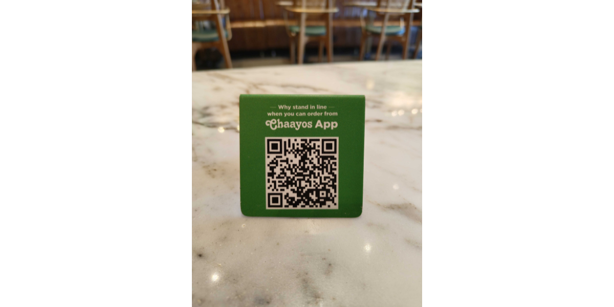 A table tent with a Chaayos QR Code.