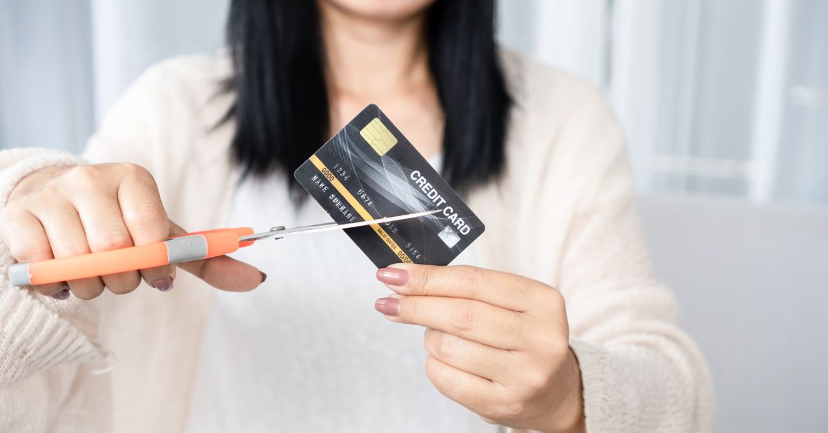 (woman cutting a credit card)