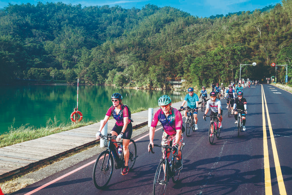 Cyclists riding along the edge of Sun Moon Lake with scenic views
