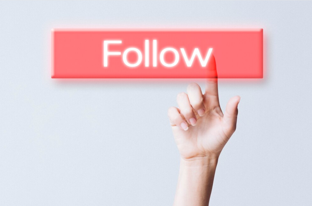 A hand clicking the "Follow" button on social media
