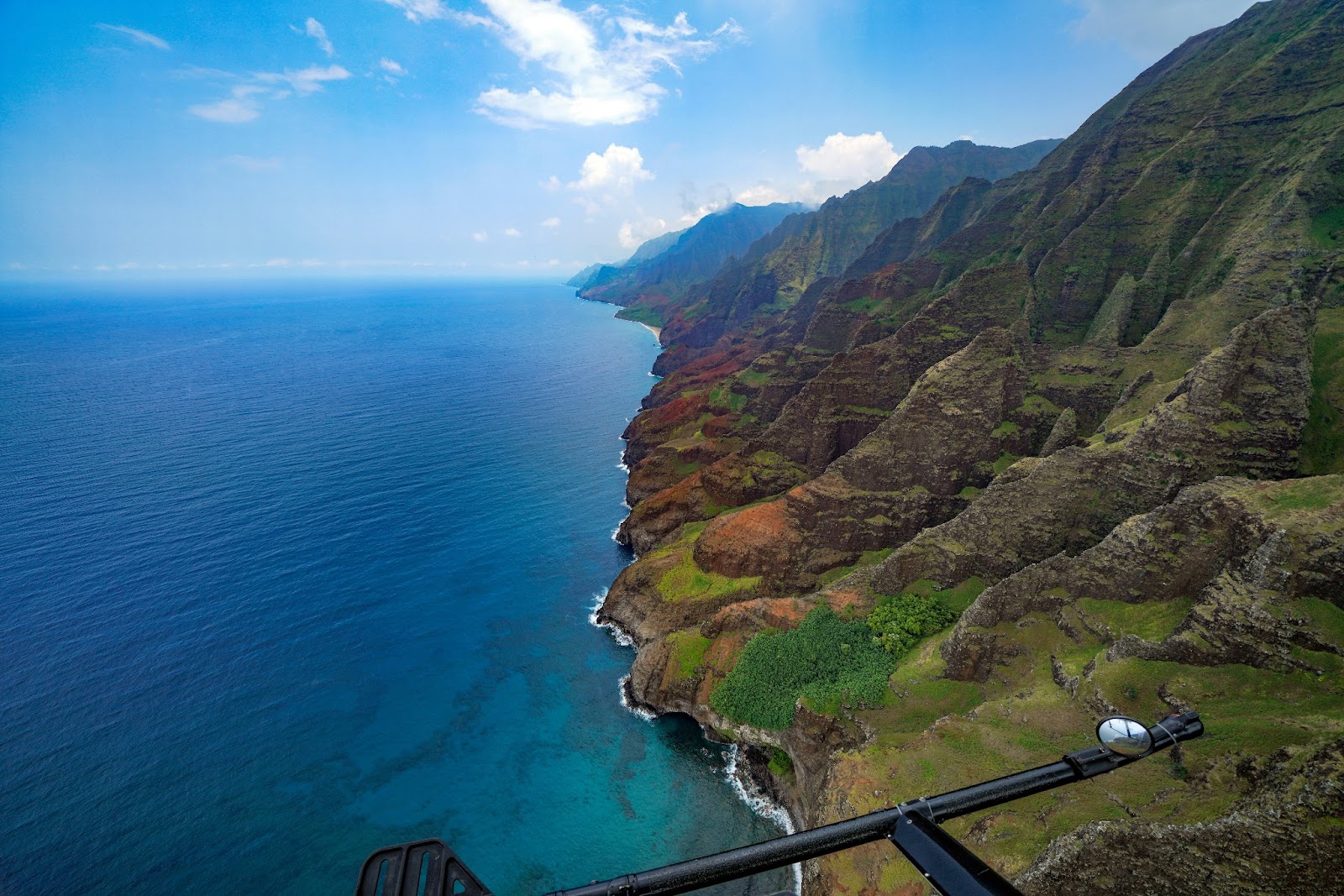 A thrilling doors-off helicopter tour flying over O‘ahu’s lush green valleys and rugged cliffs.