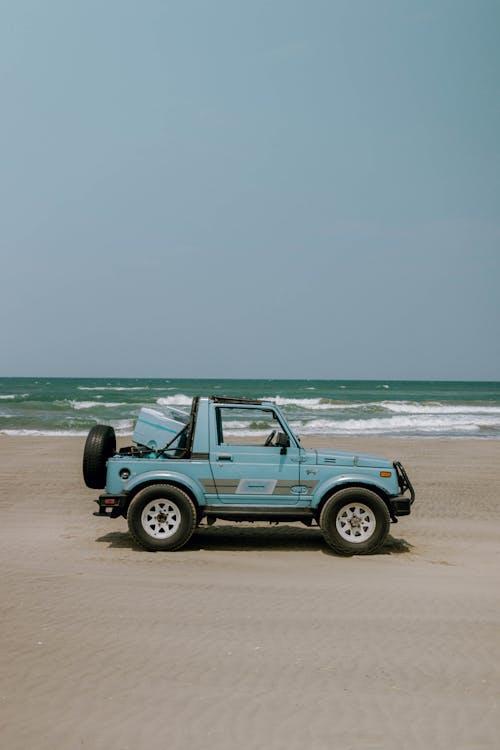 Free Blue Suzuki Jimny Standing on a Beach  Stock Photo