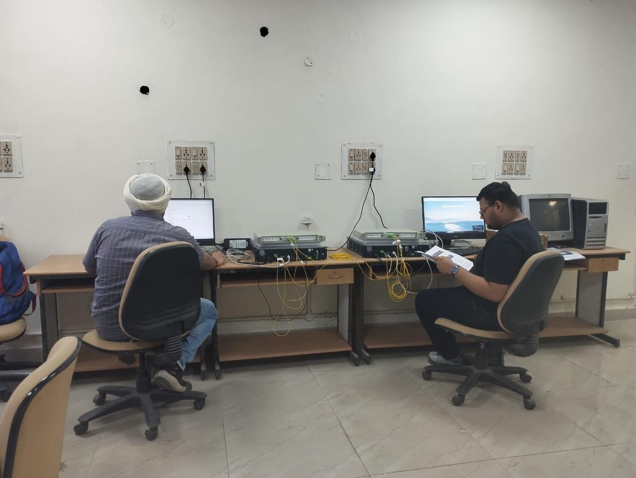 A group of men sitting at a desk with computers

AI-generated content may be incorrect.