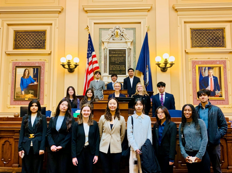 Group of FCPS students on the Virginia State Senate floor in front of pictures and flags.