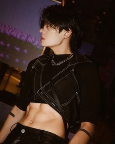 This  contain an image of KIRE with short black hair and piercings on her stomach wearing leather shorts, looking off to the side