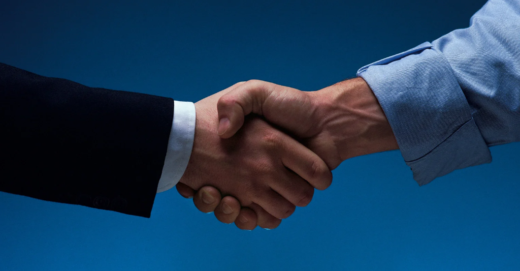 (Close-up of a firm handshake between two professionals in business attire, symbolizing trust, partnership, and a successful agreement.)