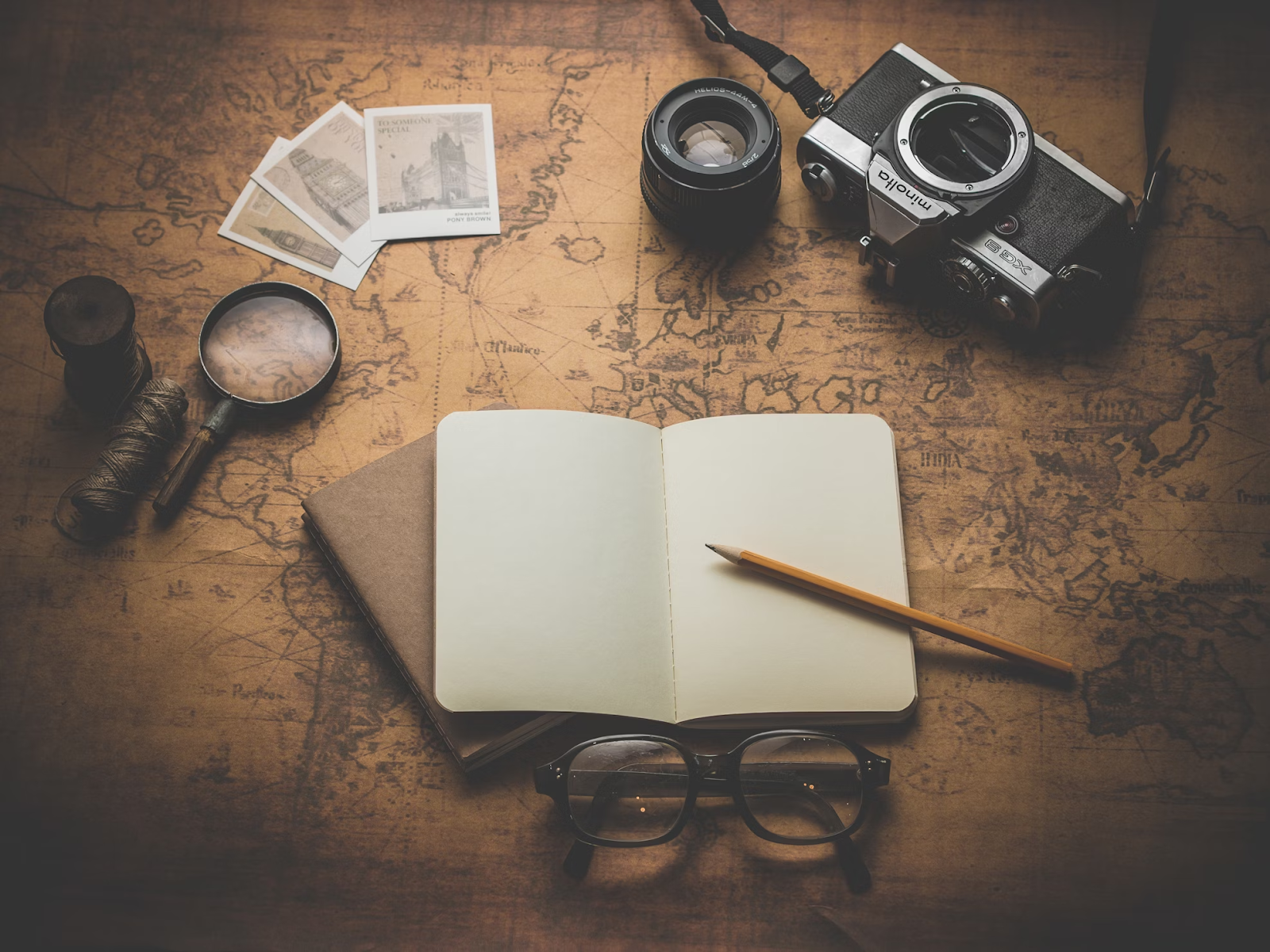 journal and pen on top of map
