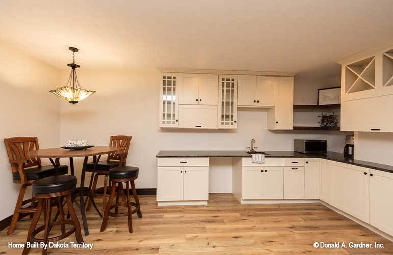 The kitchenette includes white cabinetry, black countertops, and corner shelves.