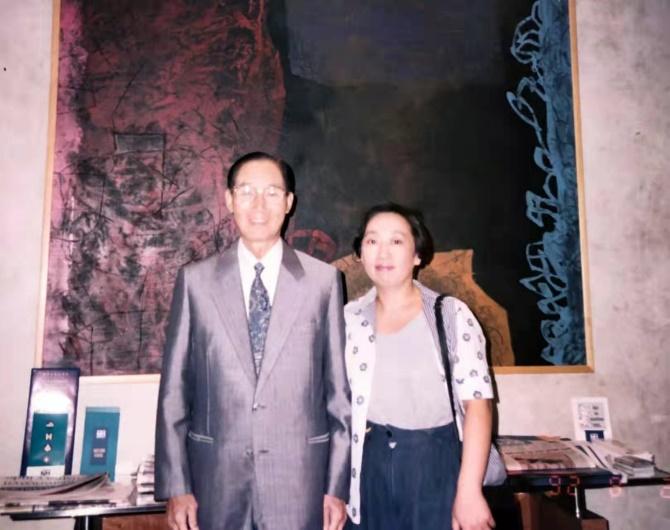 Two people standing in front of a paintingDescription automatically generated with medium confidence