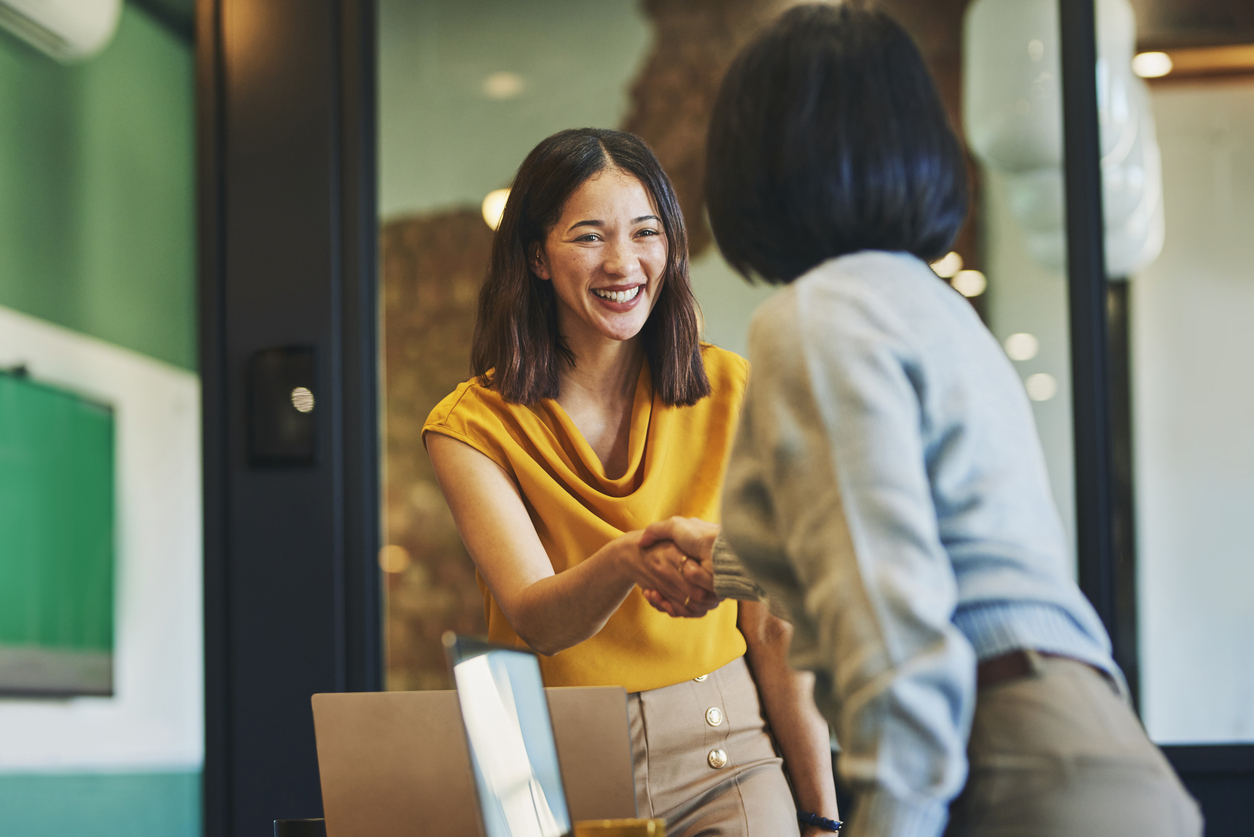 two women shaking hands in an office