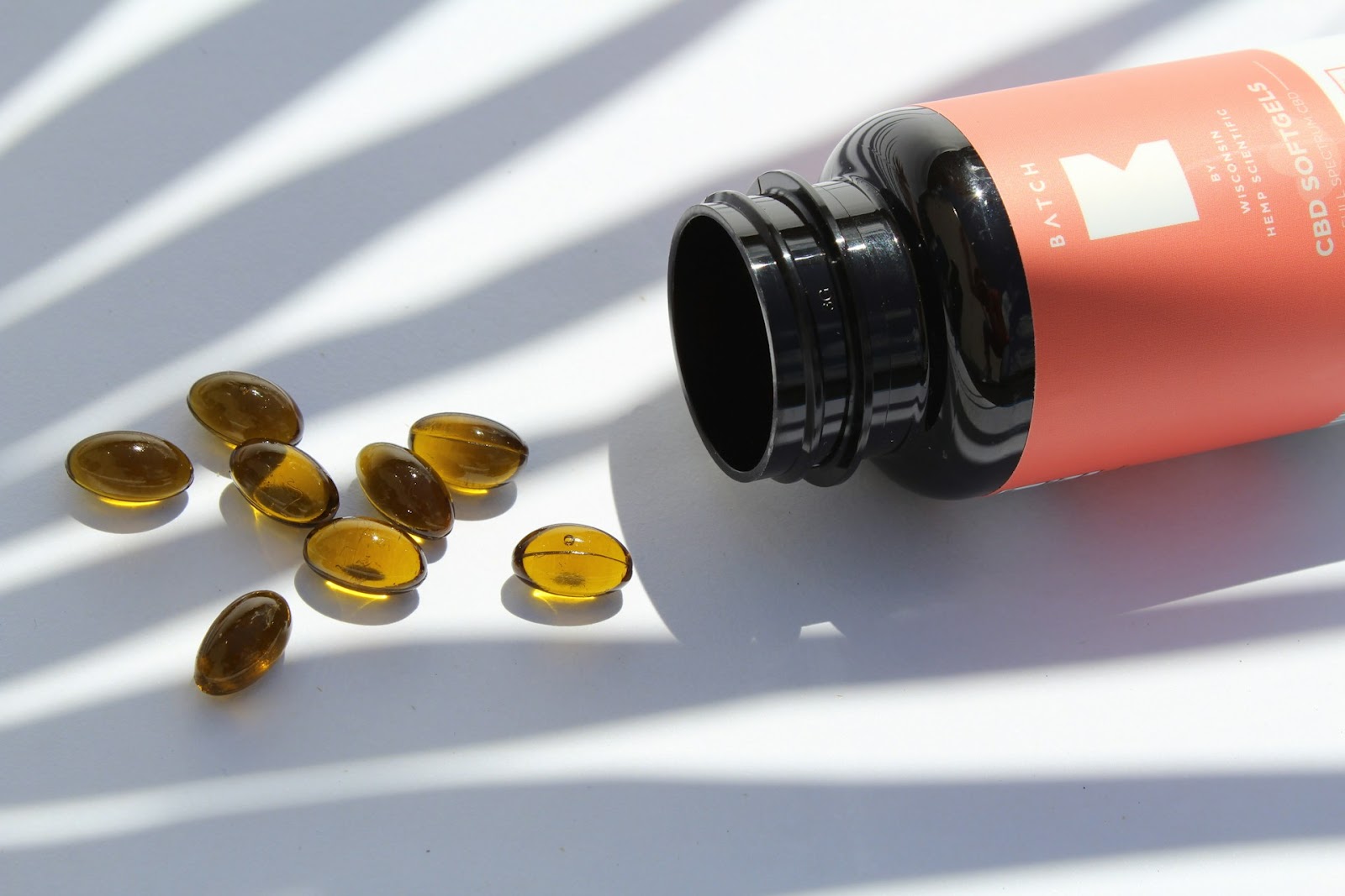 Softgel capsules and an upside-down bottle are placed on the table