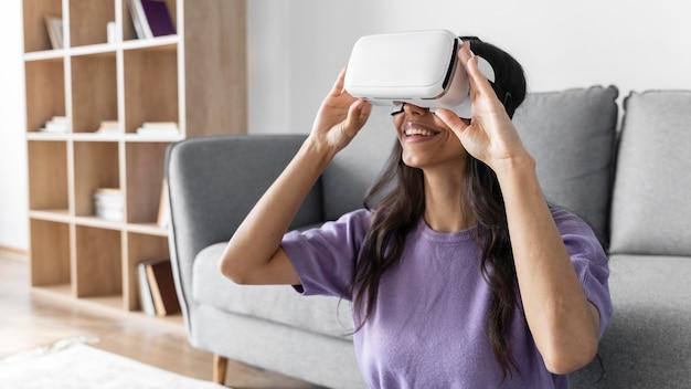 Smiley woman using virtual reality headset at home