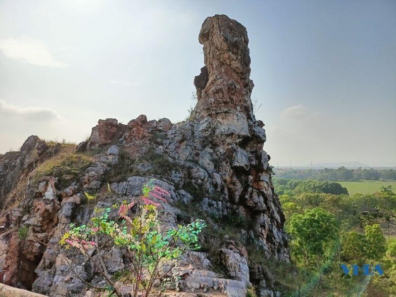 A large rock formation on a hill

Description automatically generated