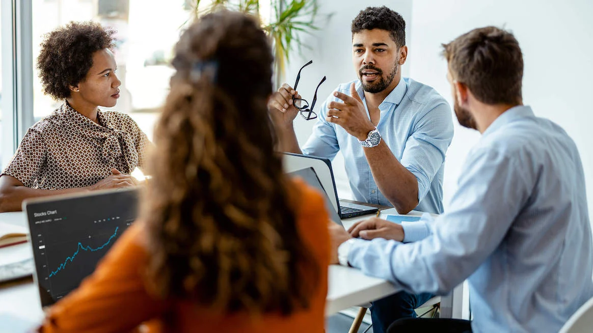  A diverse group of employees collaborating in a modern office space, representing a positive and supportive work environment that promotes well-being.