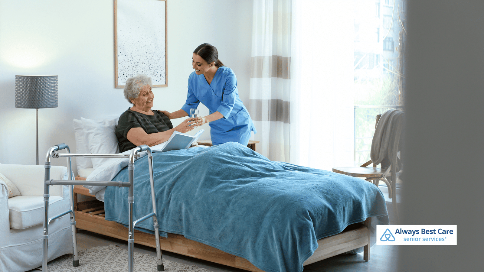 This image depicts a caregiver handing a glass of water to a senior woman while she's reading