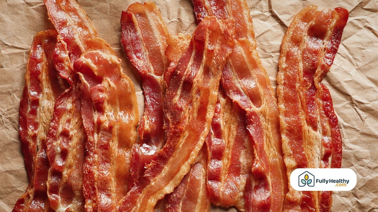 Crispy brown bacon lined up on brown parchment with FullyHealthy logo