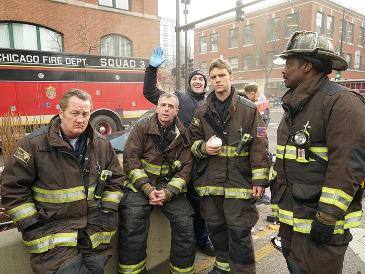 This may contain: some firemen are standing in front of a fire truck