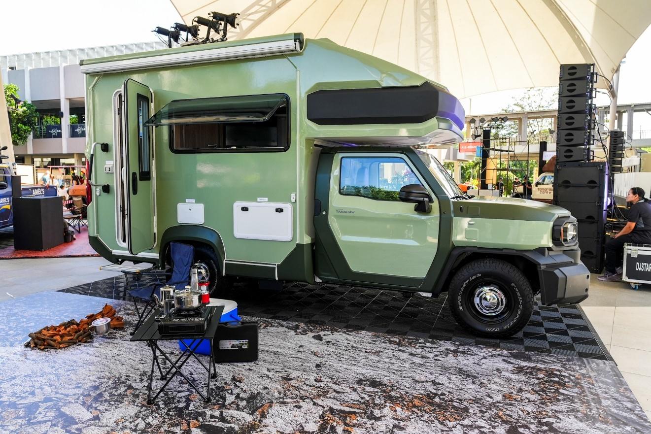 A green camper parked in a parking lot

Description automatically generated