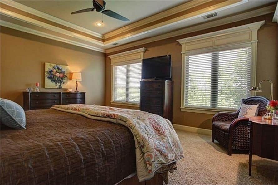 The primary bedroom includes wooden dressers and a wicker lounge chair.